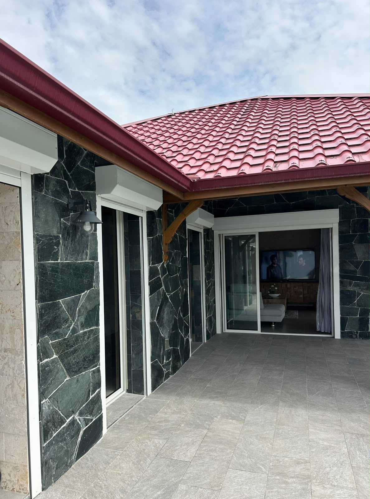 Terrasse couverte d'une villa avec façade en pierre de parement